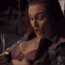a woman is sitting at a table drinking a cup of coffee .