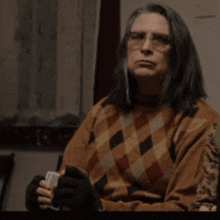 a woman wearing glasses and a plaid sweater