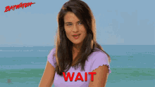 a woman in a purple shirt with the word wait written on it