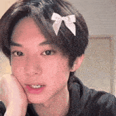 a young man with a bow in his hair