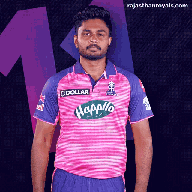 a man wearing a pink and purple shirt with happilo on it