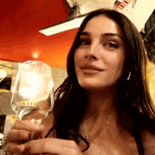 a woman is holding a wine glass with a label that says " ii " on it