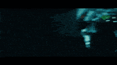a blurred image of a dark room with a green light on the ceiling