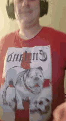 a man wearing headphones is wearing a red shirt with a picture of a bulldog on it