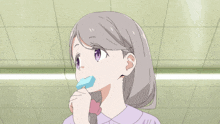 a person holding a blue popsicle with a stick that says " atari " on it