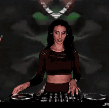 a woman in a red crop top is playing a record