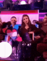 a group of people are sitting in a room with a woman in the middle