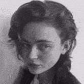 a woman with a shaved head looks at the camera in a black and white photo