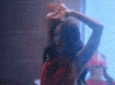 a woman in a red dress is dancing in front of a mirror in a room .