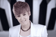 a young man with a necklace around his neck is smiling
