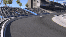 a race car is going down a race track with a crowd watching