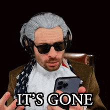 a man wearing a wig and sunglasses is holding a cell phone with the words it 's gone written on it
