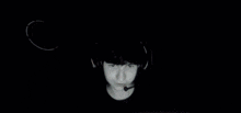 a person wearing headphones and a microphone is sitting in front of a computer screen