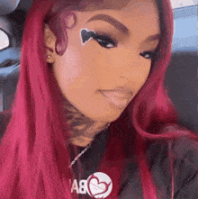 a woman with red hair is wearing a black shirt with a heart on it