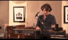 a man wearing headphones is playing a piano and singing into a microphone