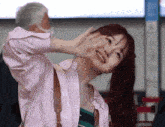 a woman wearing a pink shirt is smiling and looking up