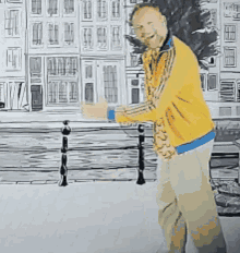 a man in a yellow jacket is standing on a sidewalk with buildings in the background