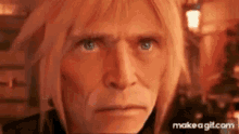 a close up of a man 's face with blonde hair and blue eyes looking at the camera .