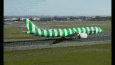 a green and white striped condor plane is taking off