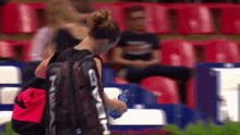 a woman with a backpack that says ' head ' on it is holding a bottle of water