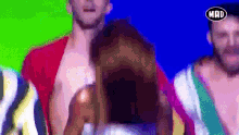 a group of men are dancing in front of a screen that says mad on it
