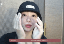 a woman wearing a black hat and gloves has a sticker on her face that says ' gahyun '