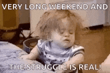 a baby is sitting on a table with a caption that says `` very long weekend and the struggle is real . ''