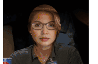 a woman wearing glasses is holding a pepsi bottle
