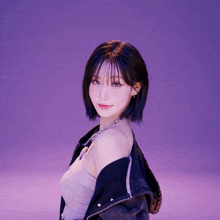 a woman with short hair is wearing a black jacket and a necklace