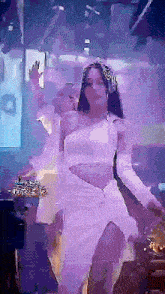 a woman in a white dress and gloves is dancing in a dark room
