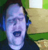 a man wearing headphones is singing into the camera .