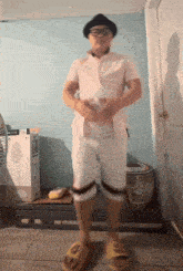 a man wearing a hat and sunglasses is standing in a room