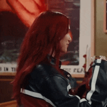 a woman with red hair is wearing a black and white jacket and holding a glass