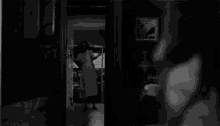 a black and white photo of a man walking down stairs .