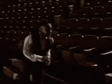 a man in a white shirt is walking down stairs