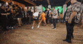 a group of people are dancing in a room with a sign that says zeus on it