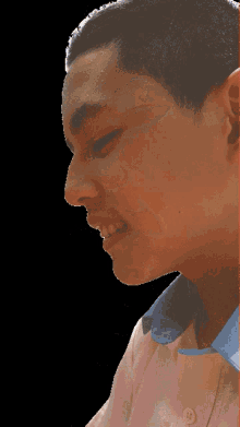 a close up of a man 's face with a pink shirt on