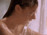a woman is taking a shower and water is pouring out of her mouth