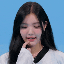 a woman with long black hair is wearing a white shirt