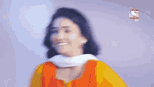 a woman is smiling in front of a wall with a sony logo on it