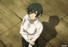 a woman in a white shirt stands on a wooden floor with her hands folded