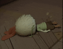 a cartoon character is laying on the floor with a chicken 's head on his back