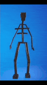 a skeleton made out of sticks is standing on a blue surface