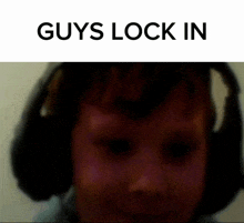 a blurry picture of a person wearing headphones with the words guys lock in above them