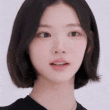 a close up of a woman 's face with short hair and a necklace