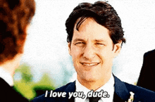 a man in a suit and tie is smiling and says i love you dude .