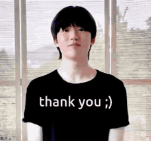 a young boy is wearing a black shirt that says thank you .