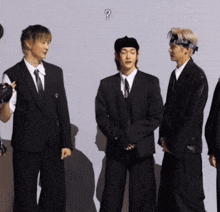 a group of men standing next to each other with a question mark in the corner