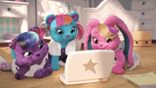 three stuffed animals look at a laptop with a star on it