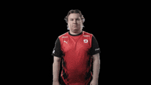a man wearing a red shirt with the letter d on the front